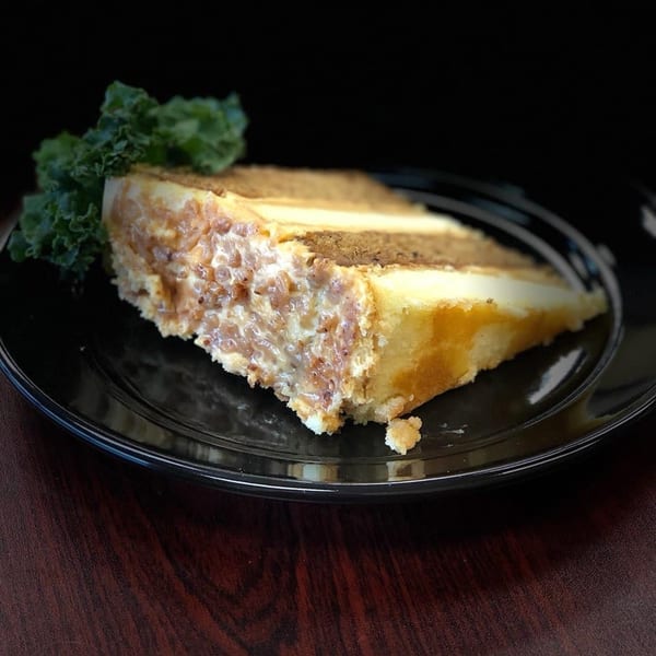 A slice of L&G Southern Soul Food's caramel cake with nuts and a kale garnish.